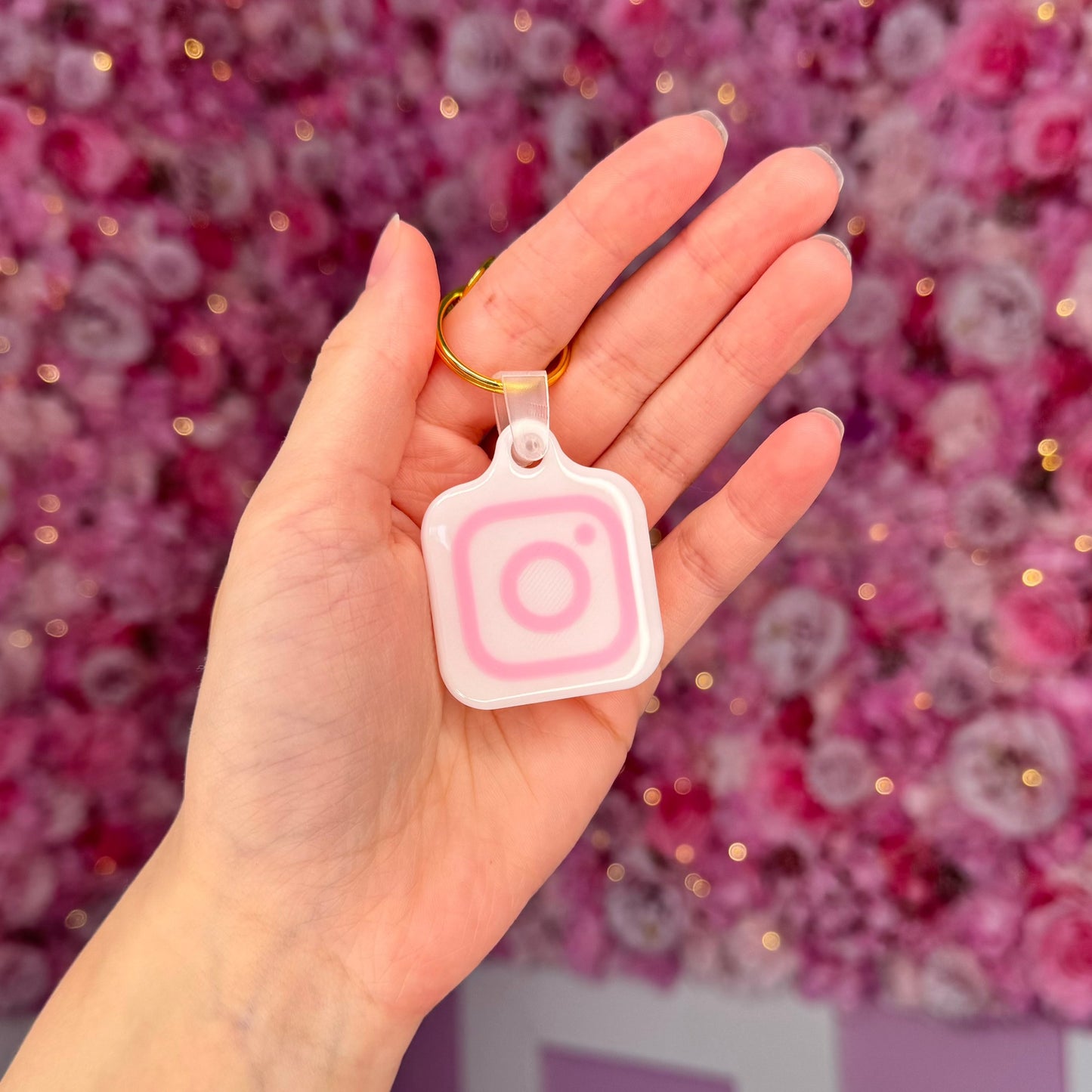 keychain with golden ring and pink instagram logo